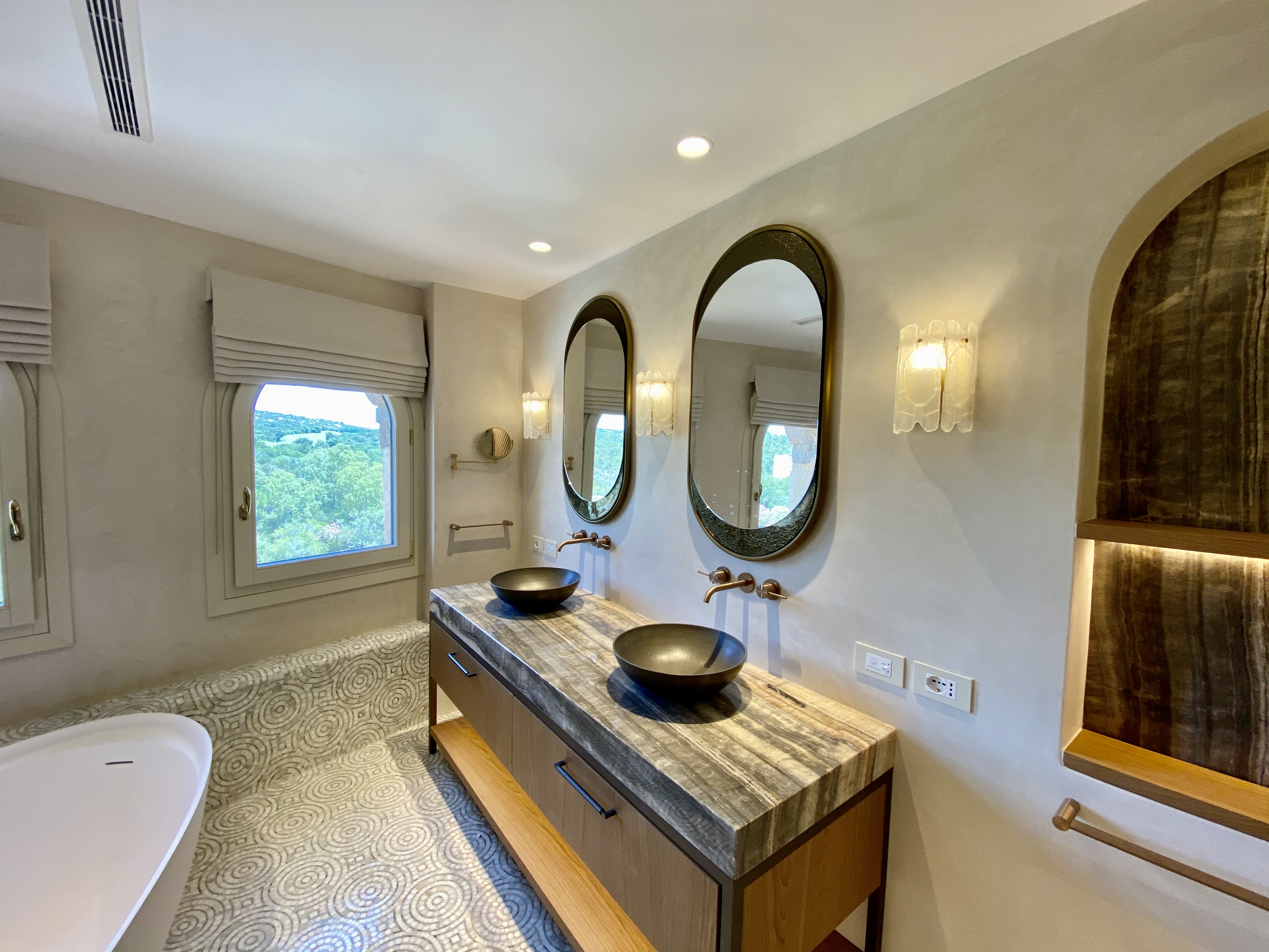 Bagno doppio con specchi ovali e piano in marmo